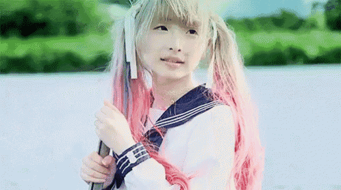 a young girl with blonde hair and pink hair is holding a sword .