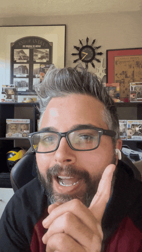 a man with glasses and a beard is talking in front of a clock that says end of an era