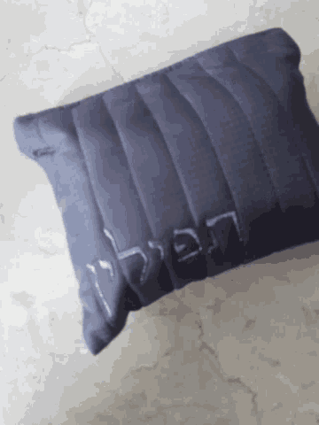 a small black pillow with letters lg on it