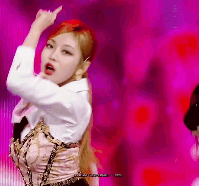 a woman with red hair is dancing in front of a pink background that says next level rec