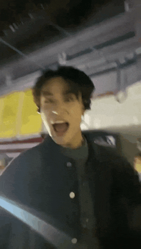 a man is making a funny face with his mouth open in a parking garage .