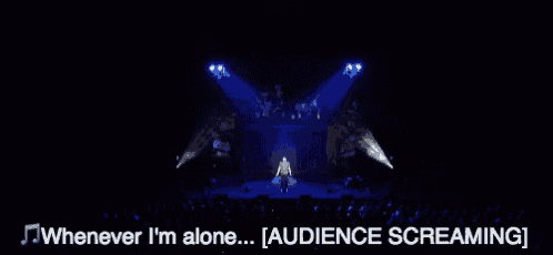 whenever i 'm alone ... [ audience screaming ] is written below a man on a stage