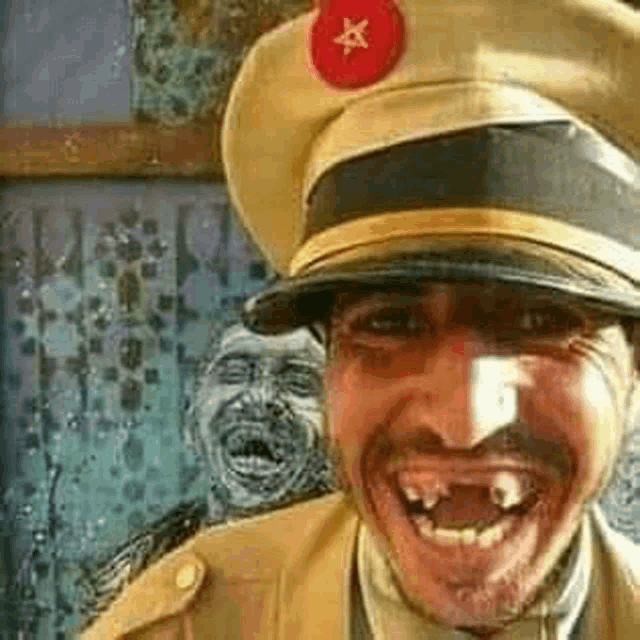 a man wearing a military hat with a red star on it is smiling with his mouth open .