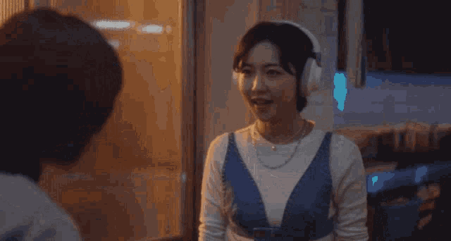 a woman wearing headphones is talking to another woman and the words woo to the young to the woo are above her