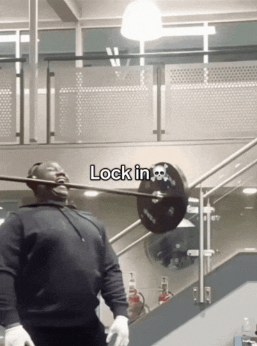 a man lifting a barbell in a gym with the words lock in at the bottom