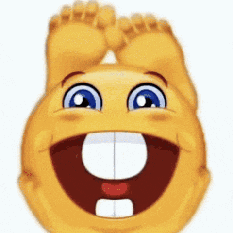 a smiley face is laughing with its feet up and a big smile on its face .