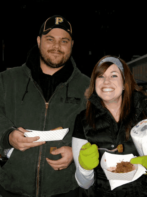 a man wearing a hat with the letter p on it is standing next to a woman