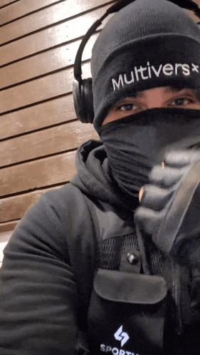 a man wearing headphones and a beanie that says multivers