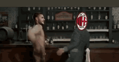 two men are standing in front of a bar with bottles and a sign that says spitfire