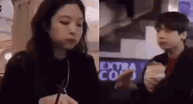 a man and a woman are sitting next to each other in a restaurant and eating .
