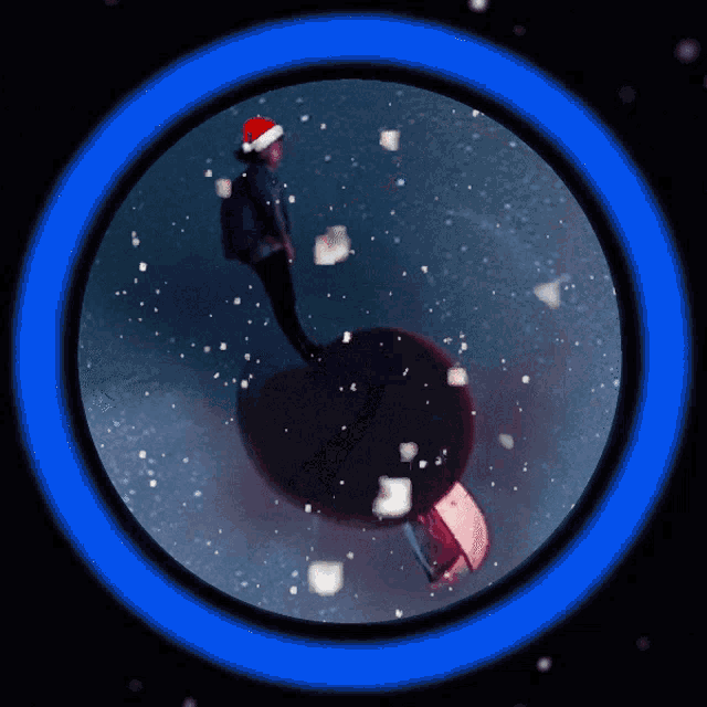 a person wearing a santa hat stands in a blue circle