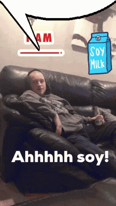 a man is sitting on a couch with a carton of soy milk behind him