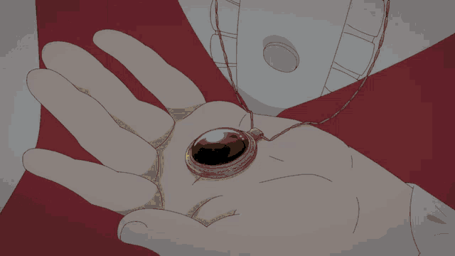 a hand is holding a gold pendant with a light coming out of it