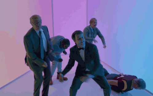 a group of men are dancing in a room and one of them is wearing a cleveland basketball jersey