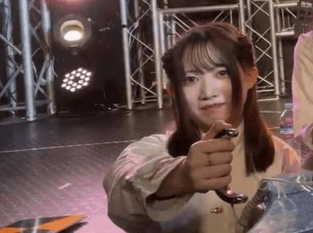 a girl is holding a snake in her hand and pointing it at the camera
