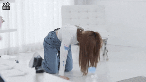 a woman is kneeling on the floor in front of a chair and a sign that says " drive "