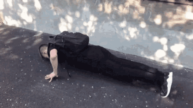 a man doing push ups on the ground with a backpack on his back