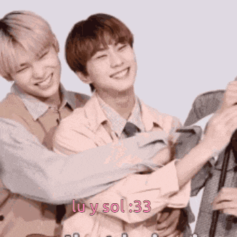 a group of young men hugging each other and smiling .