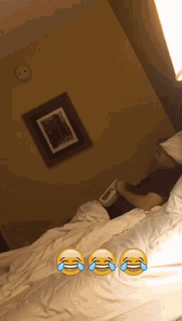 a picture of a man laying on a bed with three crying emojis on the bed
