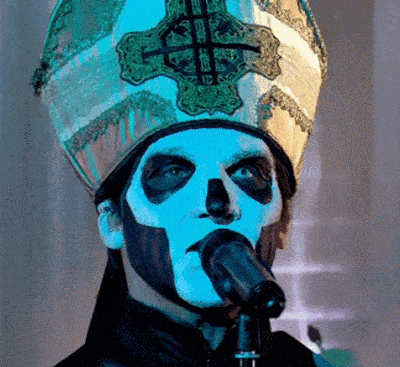 a man with a skull painted on his face is holding a microphone