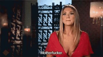 a woman in a red dress is standing in front of a screen and says motherfucker .