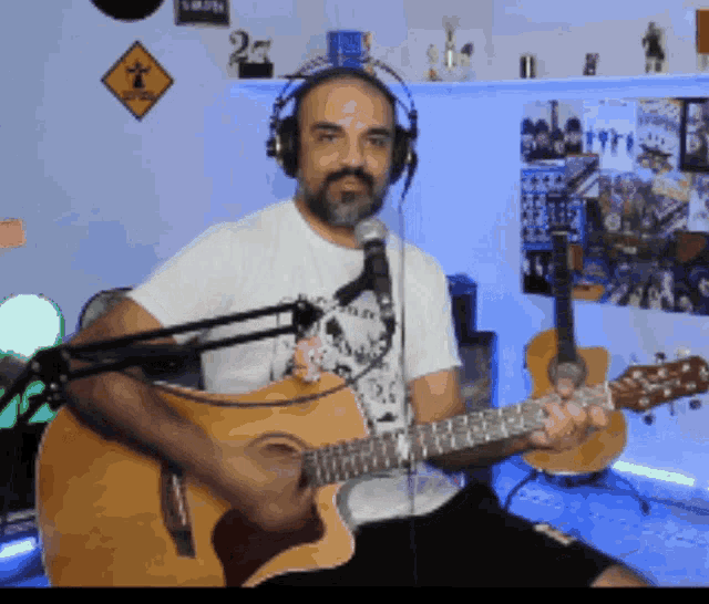 a man wearing headphones is playing a guitar