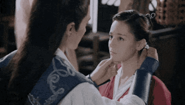 a man is putting a ring on a woman 's ear while they are looking at each other .