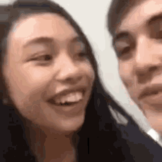 a man and a woman are smiling at each other .