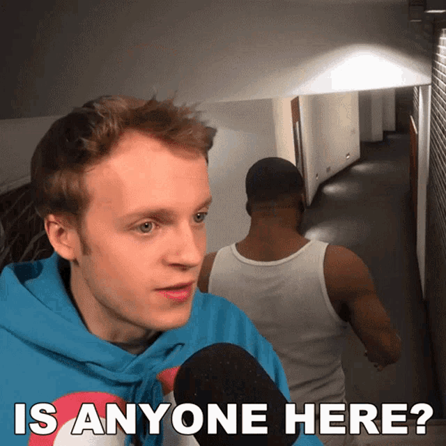 a man in a blue hoodie says " is anyone here "