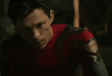 a close up of a man 's face in a spiderman suit .