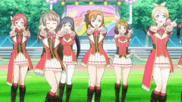 a group of anime girls are standing in front of a stage and giving the thumbs up sign