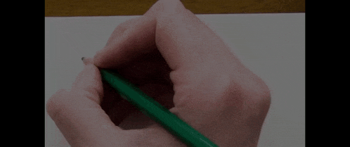 a person is writing the word gasli on a piece of paper with a green pencil