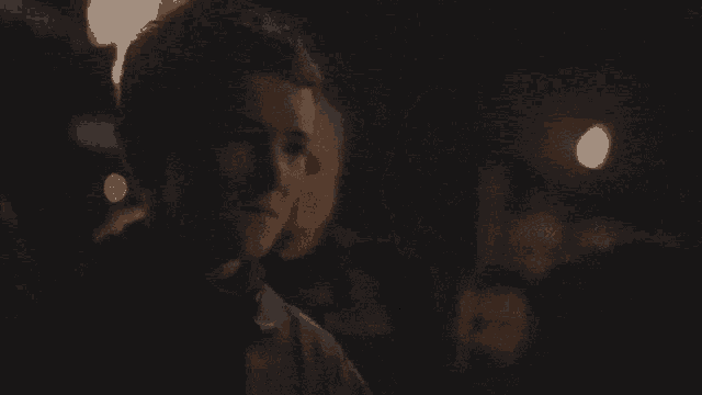 a person in a dark room with a light shining on their face