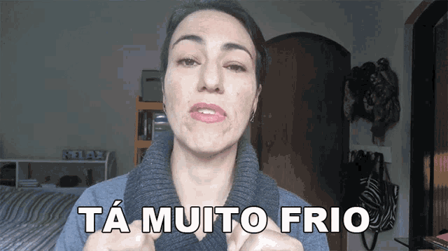 a woman says ta muito frio while wearing a sweater