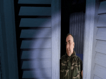 a man in a camo jacket stands in a doorway