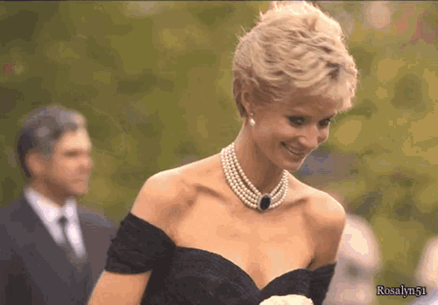 a woman wearing a pearl necklace and a black dress with the name rosalyn51 on the bottom