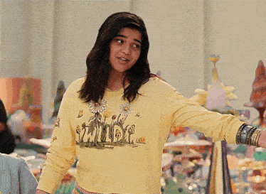 a woman wearing a yellow shirt with flowers and the word wild on it