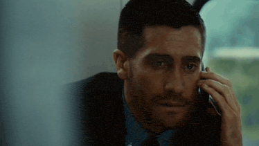 a man talking on a cell phone with his eyes closed