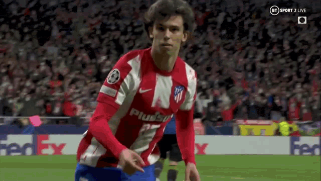 a soccer player in a red and white shirt is running on the field .
