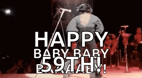 a man is standing on a stage in front of a microphone and says `` happy baby baby 59th ! ''