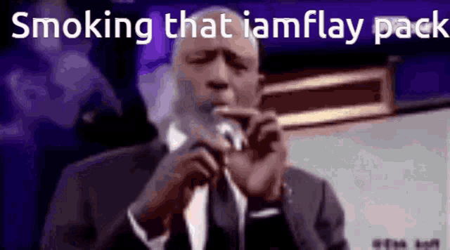 a man in a suit and tie is smoking a cigarette while talking into a microphone .