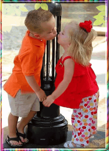 a boy and a girl are kissing in front of a lamp post that says anka on it
