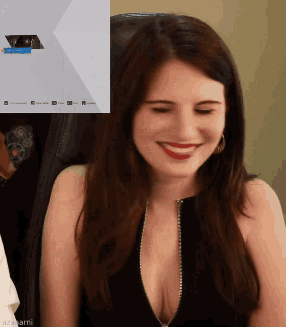 a woman is smiling in front of a screen that says ' azajami '