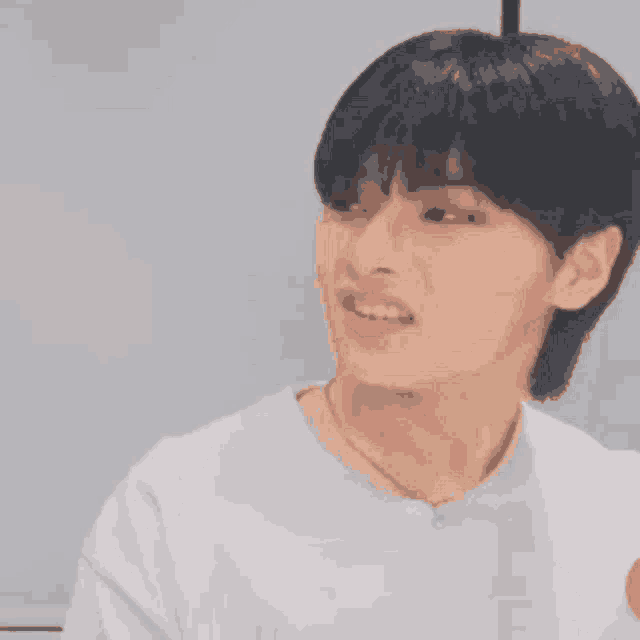 a young man with black hair is making a funny face .