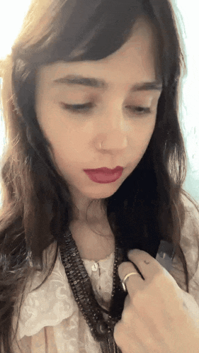 a close up of a woman 's face with a ring on her finger