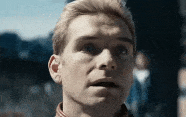 a close up of a man 's face with his mouth open and a serious look on his face .