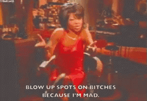 a woman in a red dress is blowing up spots on bitches because she is mad