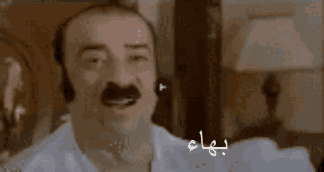 a close up of a man with a mustache and arabic writing on his face
