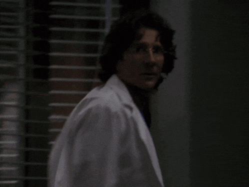 a man in a white lab coat and blue scrub top