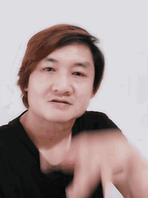 a close up of a man 's face with a black shirt on